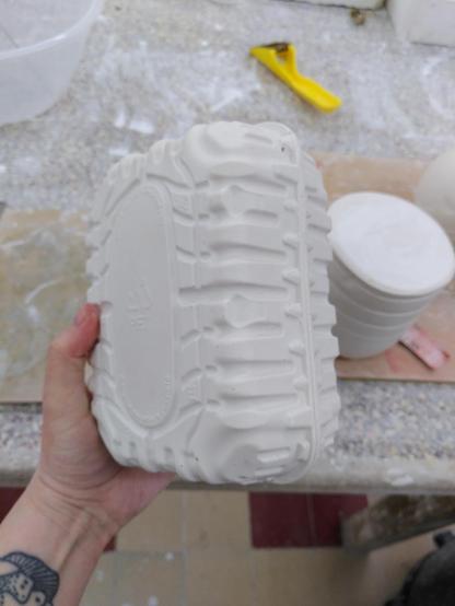 Positive plaster mold of 2 plastic containers put together.