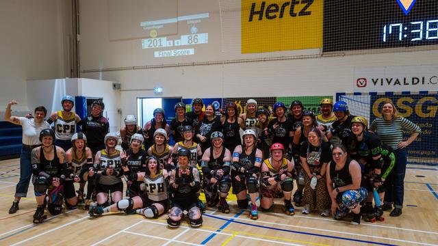 Skaters and bench crew group photo of Copenhagen Roller Derby and Team Unicorn taken after the match (version 1).