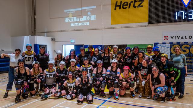 Skaters and bench crew group photo of Copenhagen Roller Derby and Team Unicorn taken after the match (version 2).