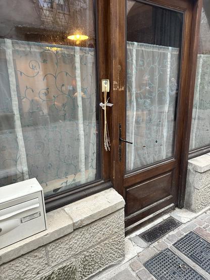Wooden door with glass windows. Bundle of wheat attached to the latch.