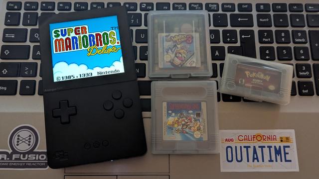 Foto des Analogue Pocket mit gestartetem Super Mario Bros. Deluxe für den Gameboy Color. Daneben drei weitere Module.