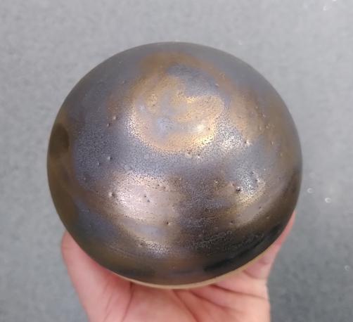 An ceramic sphere glazed with a metallic glaze