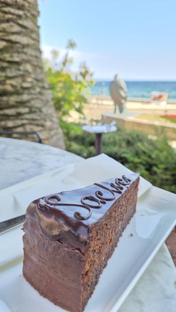 Sacher Torte im Vordergrund- im Hintergrund sieht man unscharfen das Meer in Opatija