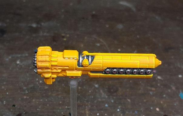 bitchin bright yellow miniature tubular spaceship with a broadside bank of deep red laser lenses.