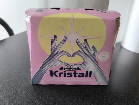 Pack en carton rose et jaune de la marque Kristall. L'illustration montre deux mains qui forment un cœur avec les pouces et les index.