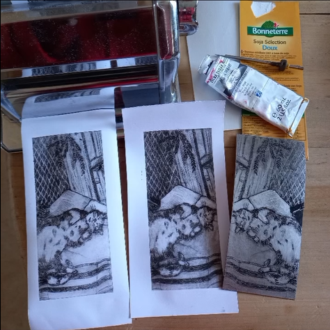 Tirages en noir et blanc réalisé à partir de brique alimentaire marquée et gravée à la pointe, encrée et imprimée à l'aide d'un laminoir à pâtes. Le sujet est un chat couché sur le dos.