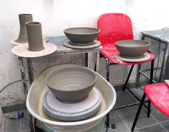 The 5 thrown clay parts of the large thrown water drop pitcher not yet put together. There are 3 large bowl shapes and 2 tubes.