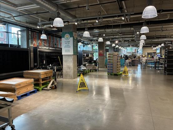 Completely vacant produce section in Whole Foods grocery store. The shelves are empty and partially disassembled.