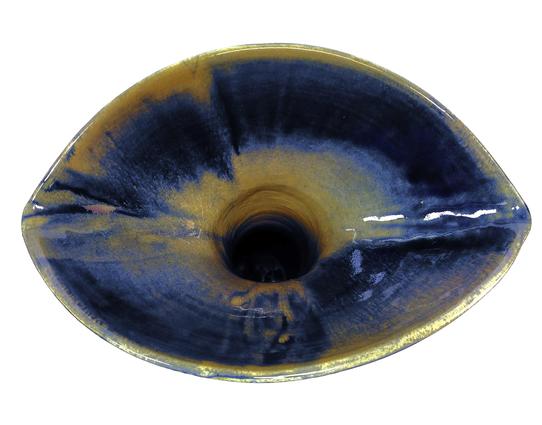 Large ceramic pitcher. View from the top of the pitcher. We only see a shape like neck opening. I looks strangely like an eye and iris.