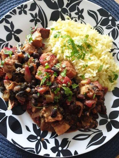 A plate of Black bean & Roasted Root Vegetables (carrot, sweet potato, parsnip, beetroot) (don't forget the onions, celery, and fresh spices) Curry, served with Basmati rice and topped with fresh coriander.
