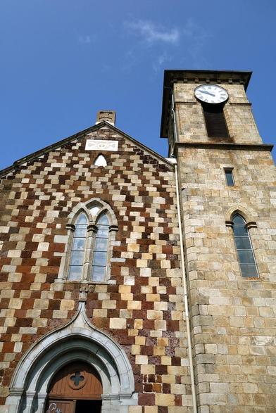 Église polylithologique (mais monothéiste) de Borée, en Ardèche. En plus du granite et de l'arkose, beaucoup de blocs sont d'origine volcanique :
- trachyte (gris, portail)
- scories soudées (rouge)
- basalte avec inclusions de péridotite
- brèche phréatomagmatique (visible sur un autre mur, pas en façade)