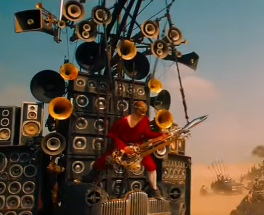 Man with a guitar and giant speaker stack (Taiko drummers back behind the speakers)