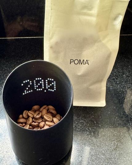 Subminimal Subscale dosing cup with 20g coffee beans from POMA, bag in background
