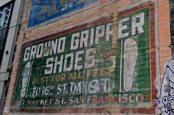 Fading painted sign for "Ground gripper shoes, best for all feet"