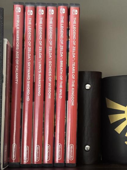 Nintendo Switch game cases on a shelf for all the Zelda games sold on the system. This includes:
* Hyrule Warriors: Age of Calamity
* The Legend of Zelda: Skyward Sword HD
* The Legend of Zelda: Link's Awakening
* The Legend of Zelda: Echoes of Wisdom
* The Legend of Zelda: Breath of the Wild
* The Legend of Zelda: Tears of the Kingdom
