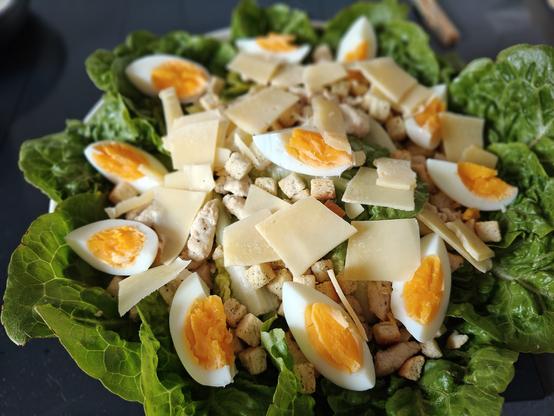 Een Caesar salade. Met ei, croutons, stukjes kip en extra belegen boerenkaas.