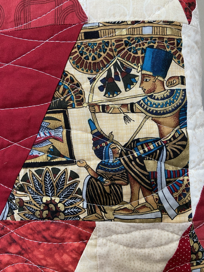 Close up of fabric with pharaoh on thrown using a bow and arrow.