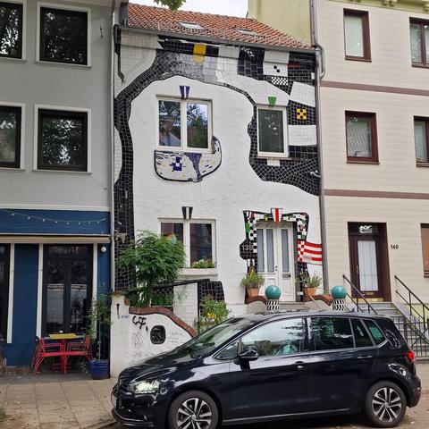 Interesting façade in Bremen, with organic shapes in colorful tiles on a white painted brick