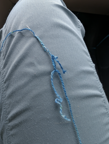 starting a Russian splice - one strand of yarn is threaded through a needle and the needle is inserted back on itself, the other strand is pulled through the resulting loop
