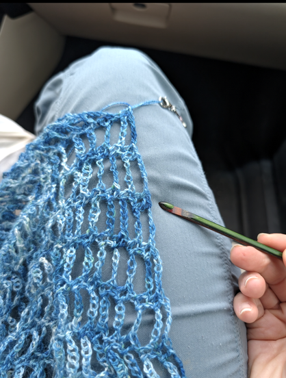 crochet-lace wrap with the Russian splice worked as two adjacent double-crochet stitches - I'm pointing it out with my crochet hook. I can see the slight thickness in that spot, but once I get a few more rows in, my guess is it'll be totally invisible