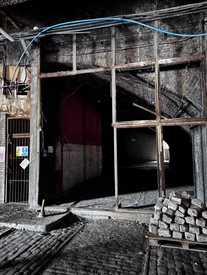 One of the arches to the left, covered with a grid that used to hold some kind of wall.