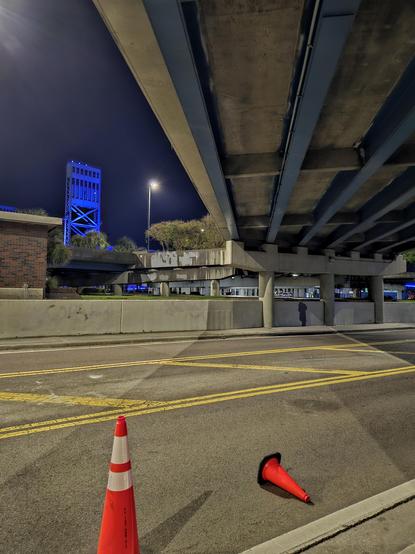 Late night view from beneath the onramp to Jacksonville's iconic Main Street Bridge, seen illuminated in blue.