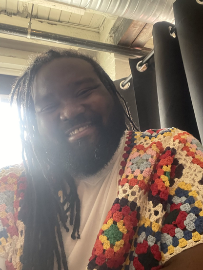 My bf, wearing a cardigan, and smiling.