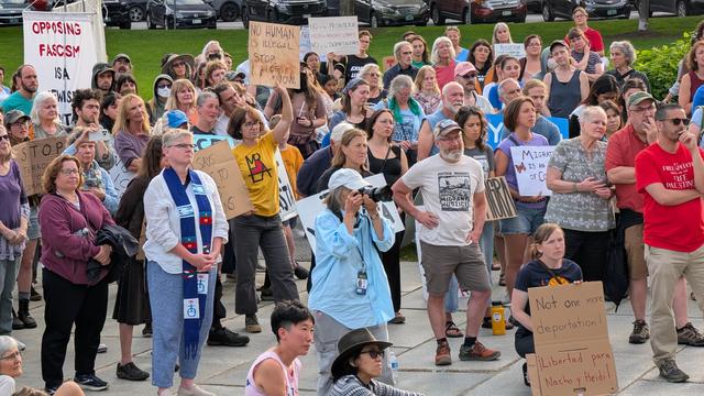 Large crowd of protesters, with signs like "no human is illegal" and "not one more deportation"
