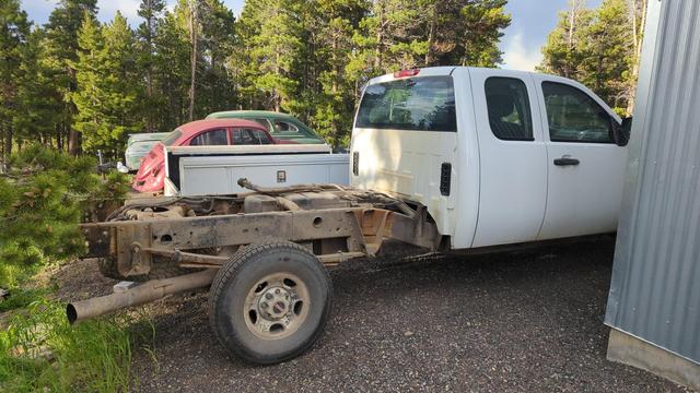 A 2007 GMC Sierra 2500HD with the bed removed (the bed is just visible past the truck). The rear frame is completely exposed, and looks very odd and skeletal compared to the beefy truck cab.