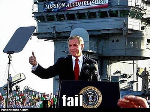 Evil warmonger Bush, puppet of the military and oil industries, giving a thumbs up to soldiers on a US aircraft carrier, with behind him a large banner with the text "mission accomplished". In front the words fail have been added.
