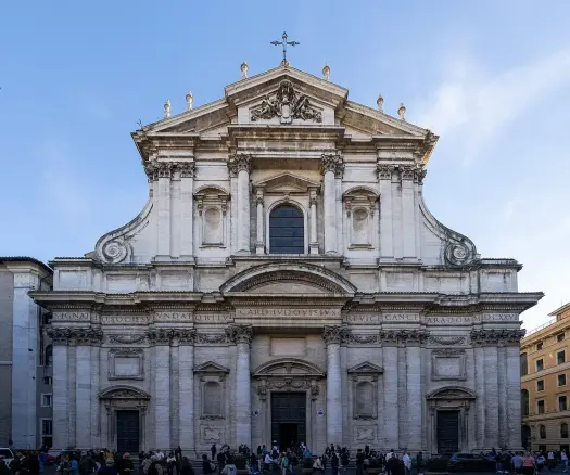 The image depicts the façade of a church, characterized by its grand architecture. It features prominent details such as columns, statues, and decorative elements at the top, as well as a large central entrance. The sky in the background is clear, indicating a bright day. Additionally, there are people gathered at the bottom, suggesting that the location is a well-visited site. If you have any specific questions about it, feel free to ask!

Image Credits: Wikimedia / Fiat 500e / CC BY 4.0