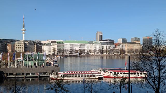 Foto aus dem zweiten Stock auf die Binnenalster. Der Jungfernstieg, der Alsteranleger und im Hintergrund sind der Hamburger Fernsehturm zu sehen.