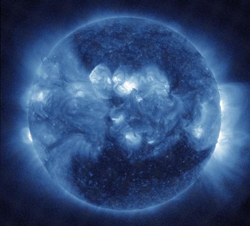 Die ganze erdzugewandte Seite der Sonne in blauen Farbtönen. Aktive Regionen besonders in der Mitte knapp über dem Sonnenäquator in heller Darstellung und etwas diffus wie weißliche Wolken aussehend. Im Gegensatz dazu ist nahezu der gesamte untere Bereich sehr dunkel wiedergegeben, was für ein sogenanntes koronales Loch spricht, eine Region in der Korona, also in der Atmosphäre der Sonne, das geringere Dichte als üblich hat und daher den Sonnenwind leichter durchlässt. Am seitlichen Rand und da besonders rechts weit ins All reichende Strahlen.