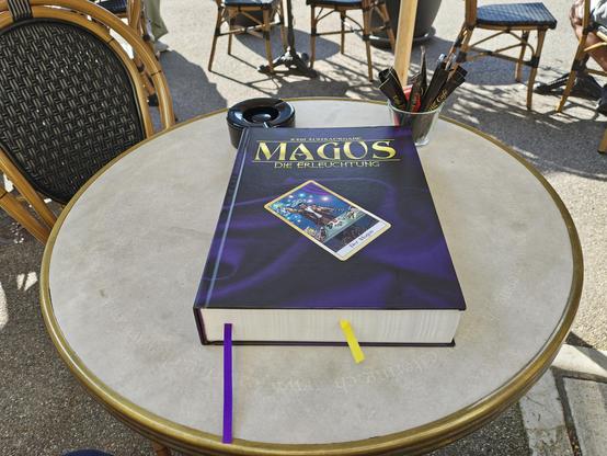 Magus die Erleuchtung Regelwerk auf einem kleinen Cafétischchen