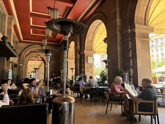 Cafe seating beneath a loft arcaded walkway.