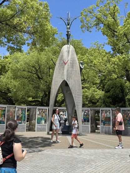 The children’s memorial at Hiroshima Peace Memorial Park, a domed structure with the statue of a child on top and a bell underneath. Surrounded by thousands of origami cranes.