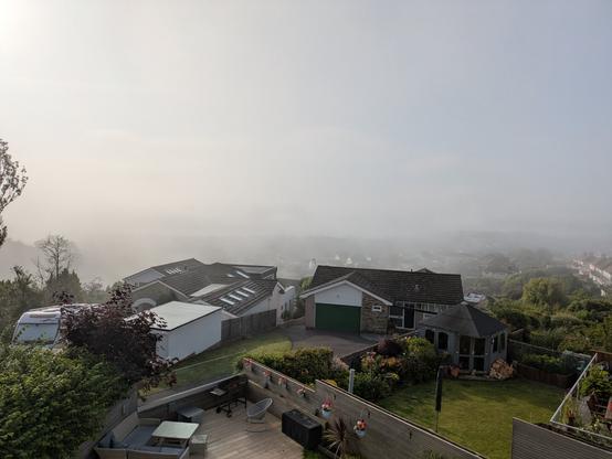 A view out over Paignton sea front. The sea is not visible because of the mist. Some houses are visible in the foreground.