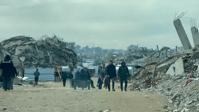 Das Bild zeigt Menschen in einer von völliger Verwüstung und Zerstörung gekennzeichnetem Wohngebiet.
Foto: Jaber Jehad Badwan