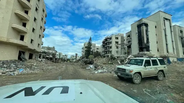 Das Bild zeigt zwei UN-Fahrzeuge in einer zerstörten Stadt.
Foto: Jaber Jehad Badwan