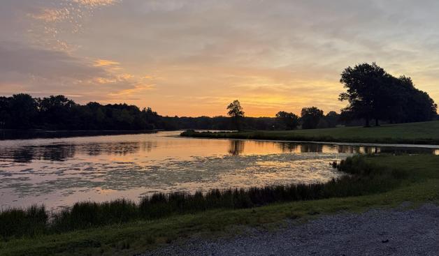 Early morning sunrise reflected off of a lake in the foreground lots of great color, reds and oranges