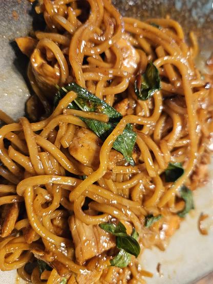 Orange and yellow noodles with bits of green leaves.