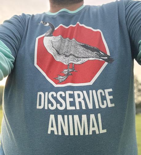 Fat guy wears a blue shirt with a Canada goose, red octagon behind it. Big white letters read disservice animal
