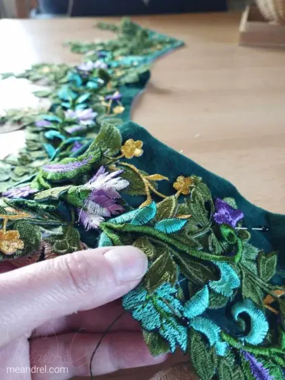 Photo d'une bande de tissu verte couverte de fleurs et feuilles en tissus.