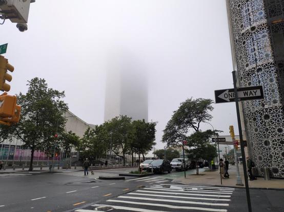 A view of United Nations headquarters, with its top half covered in fog and mist.