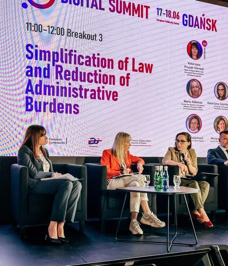Zdjęcie panelistek na tle baneru zapowiadającego panel
