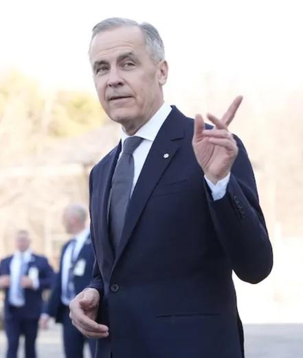 Former Banker and PM of Canada Mark Carney pointing at article to right