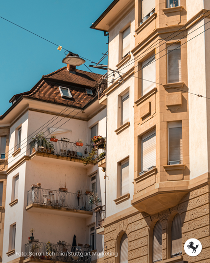 Drei Balkone an einer besonnten Häuserfassade in Stuttgart-West mit Pflanzkübeln und Sitzpätzen.