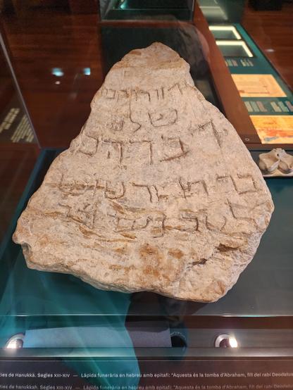Large, roughly triangular stone with about five short lines of Hebrew carved in large characters.
