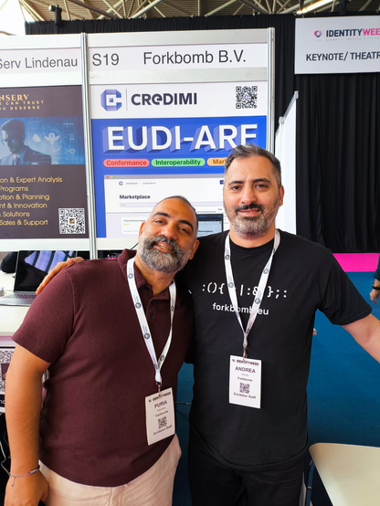 Puria and Andrea, smiling together in front of their booth