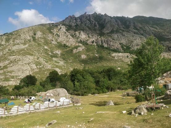Photo de tentes dans un enclos au pied d'une montagne